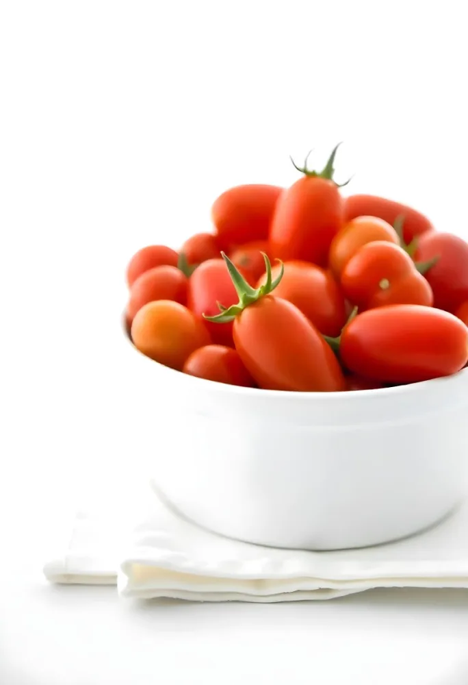 Cherry Tomatoes In A Red Bowl The Tomatoes Are Red And Ripe The Background Is Red And Out Of Focus 27 100c