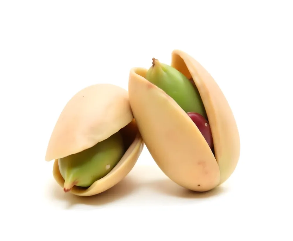Two Pistachios One Closed And One Open Revealing The Green Nut Inside On A Green Background 20 5180