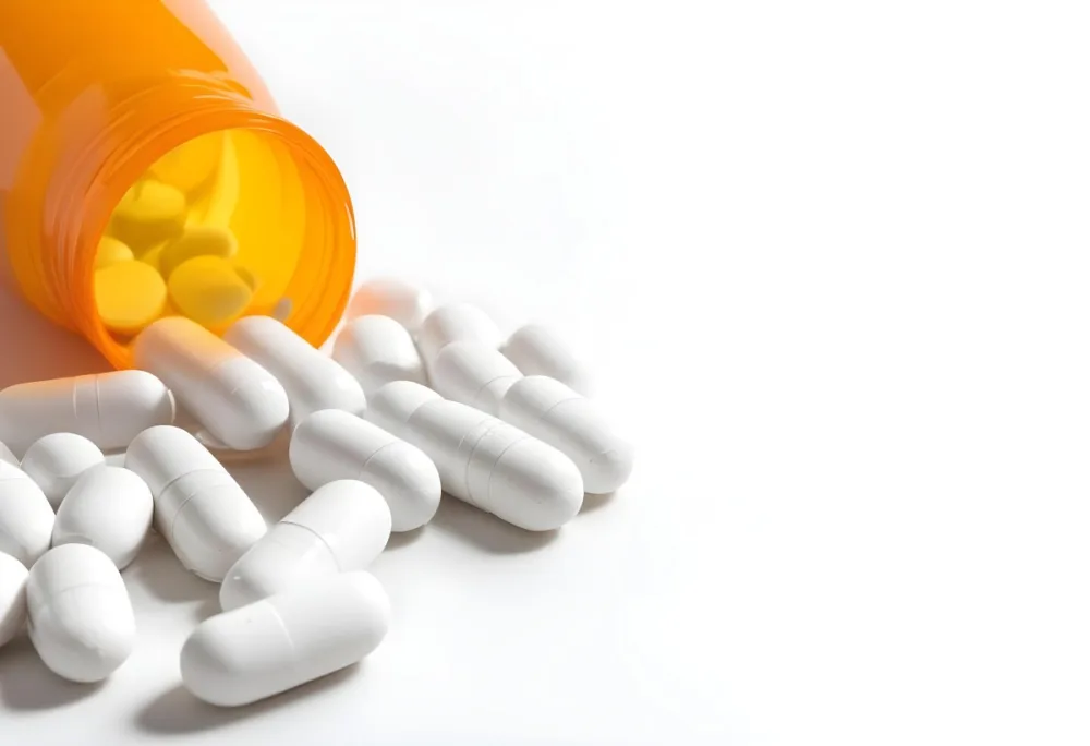 White Pills Spilling Out Of An Orange Pill Bottle On A White Surface Studio Shot 3 0e86