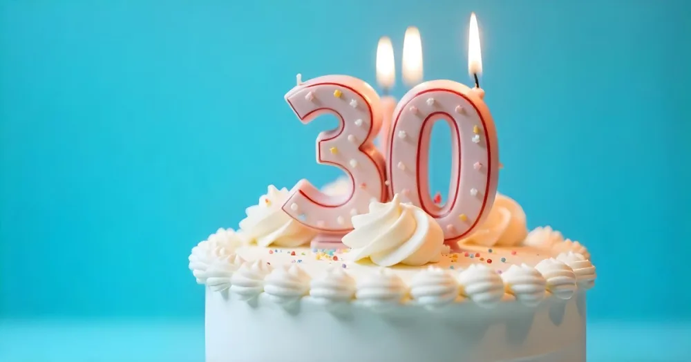 A 30th Birthday Cake With Candles On Top White Frosting And Sprinkles On A Blue Background 2 Ffa5