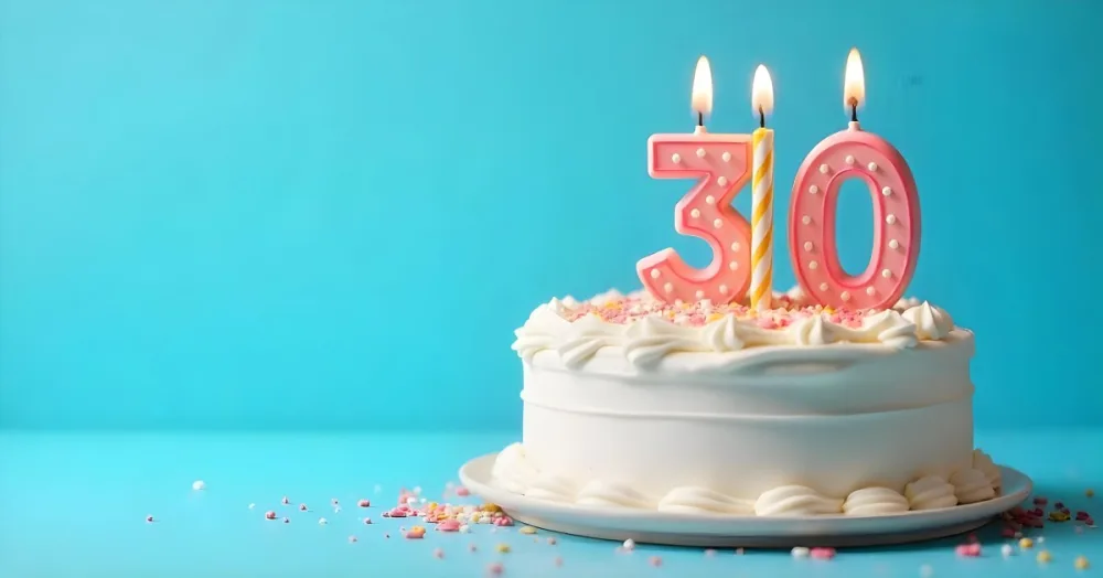 A 30th Birthday Cake With Candles On Top White Frosting And Sprinkles On A Blue Background 4 3556