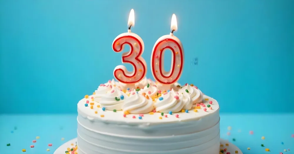 A 30th Birthday Cake With Candles On Top White Frosting And Sprinkles On A Blue Background 6 3c29