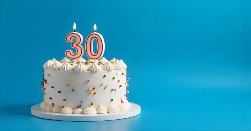 A 30th Birthday Cake With Candles On Top White Frosting And Sprinkles On A Blue Background 7 Ec71