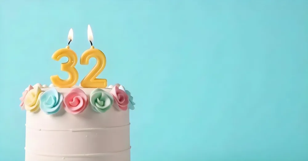 A Birthday Cake With Pastel Colors And A Number 32 Candle On Top In Front Of A Blue Background 6 0799