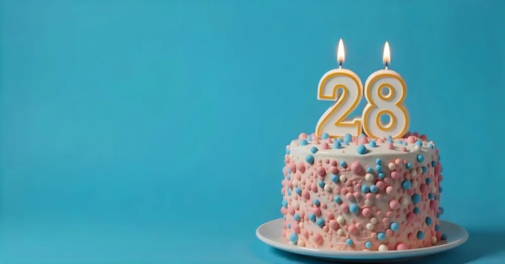 A Cake With Pink And Blue Frosting And A Candle With The Number 28 On A Blue Plate In A White Background 1 4215