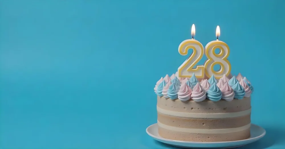 A Cake With Pink And Blue Frosting And A Candle With The Number 28 On A Blue Plate In A White Background 13 B292