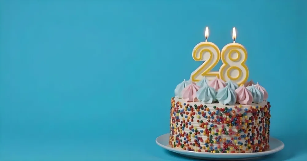 A Cake With Pink And Blue Frosting And A Candle With The Number 28 On A Blue Plate In A White Background 9 94c9