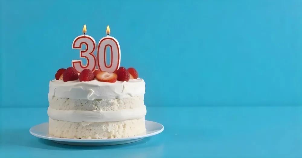 A Cake With Strawberries And Raspberries On Top With A Number 30 Candle On A Blue Background 18 28f5