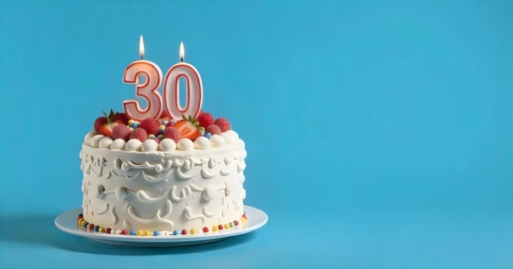 A Cake With Strawberries And Raspberries On Top With A Number 30 Candle On A Blue Background 19 F98a