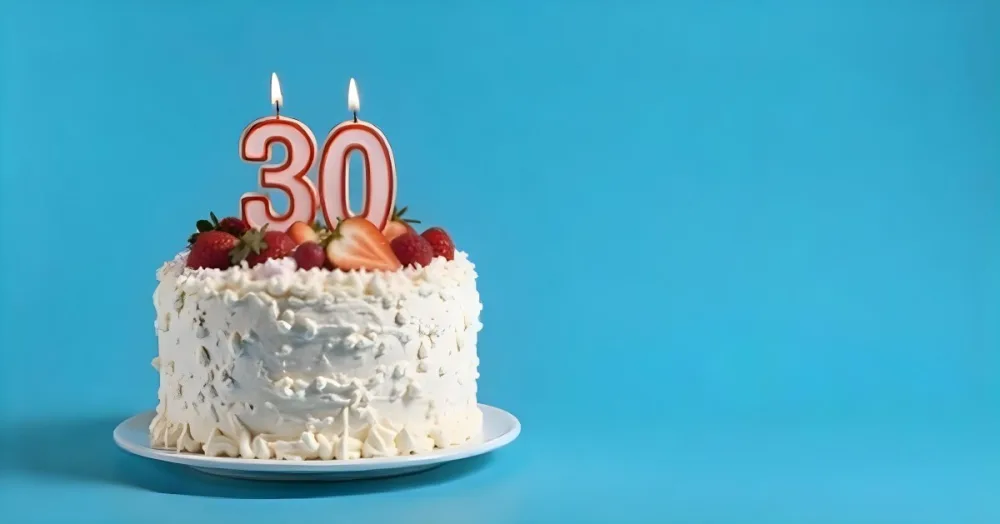 A Cake With Strawberries And Raspberries On Top With A Number 30 Candle On A Blue Background 2 96eb