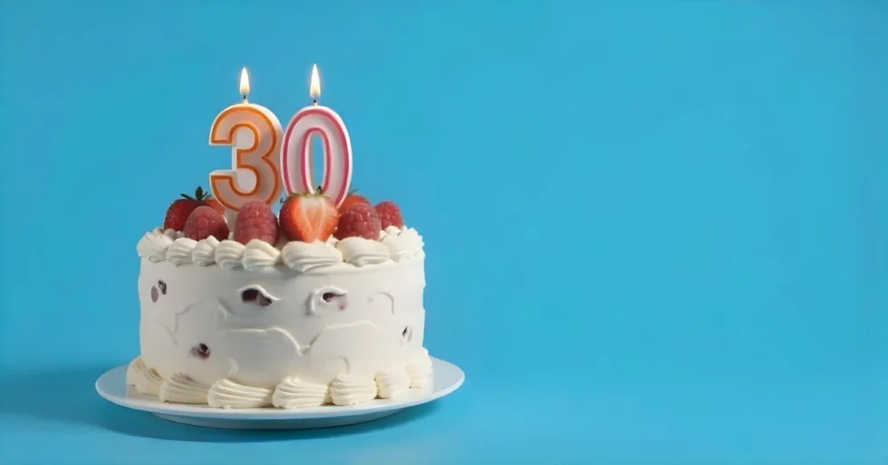 A Cake With Strawberries And Raspberries On Top With A Number 30 Candle On A Blue Background 5 434a
