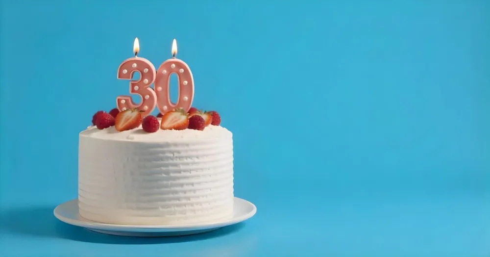 A Cake With Strawberries And Raspberries On Top With A Number 30 Candle On A Blue Background 6 2c70