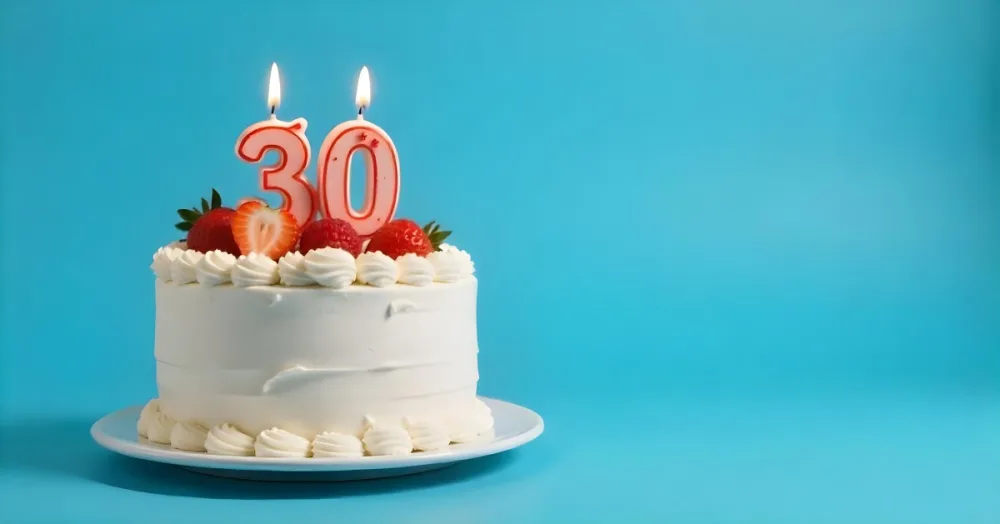 A Cake With Strawberries And Raspberries On Top With A Number 30 Candle On A Blue Background 9 5395