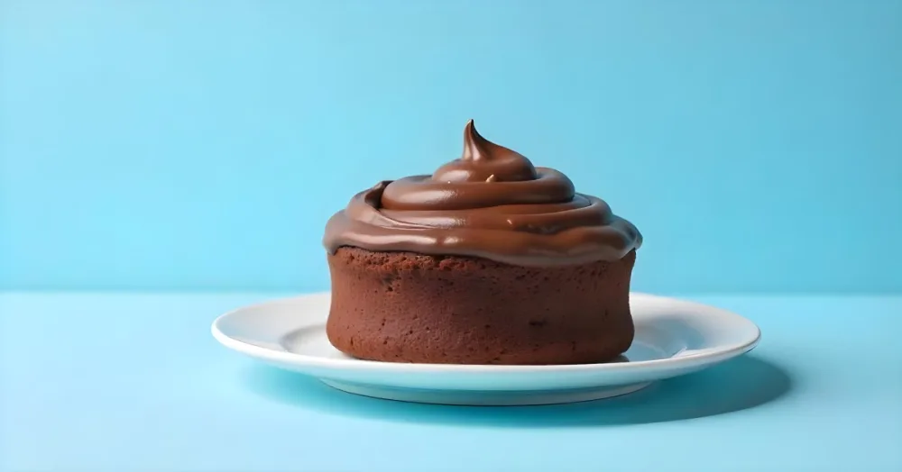 A Chocolate Cake With Chocolate Frosting On A White Plate Plain Blue Background Studio Shot Minimalist Food Photography 16 D8b6