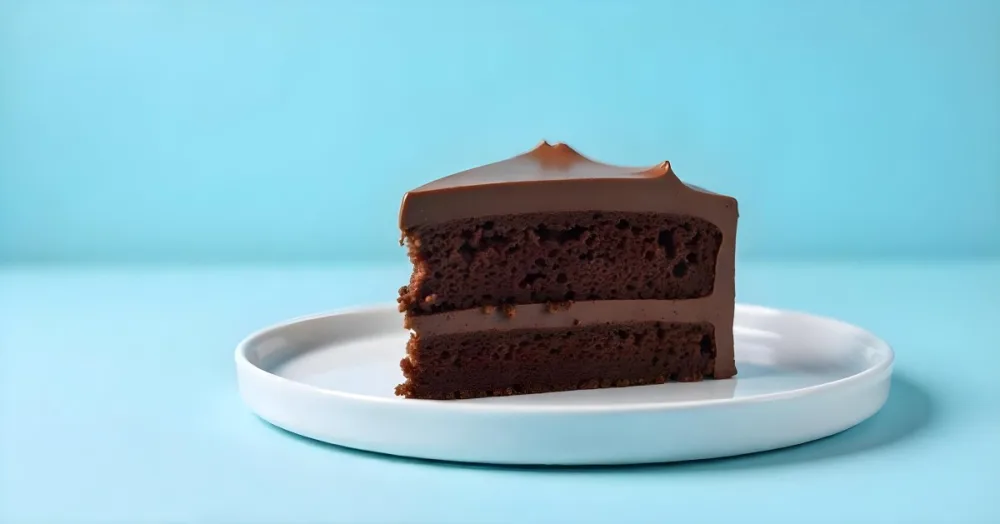 A Chocolate Cake With Chocolate Frosting On A White Plate Plain Blue Background Studio Shot Minimalist Food Photography 18 8faf