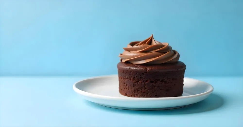 A Chocolate Cake With Chocolate Frosting On A White Plate Plain Blue Background Studio Shot Minimalist Food Photography 6 66a7