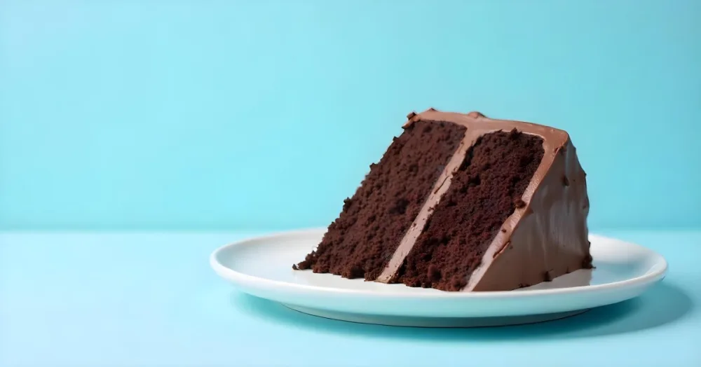 A Chocolate Cake With Chocolate Frosting On A White Plate Plain Blue Background Studio Shot Minimalist Food Photography 7 6417