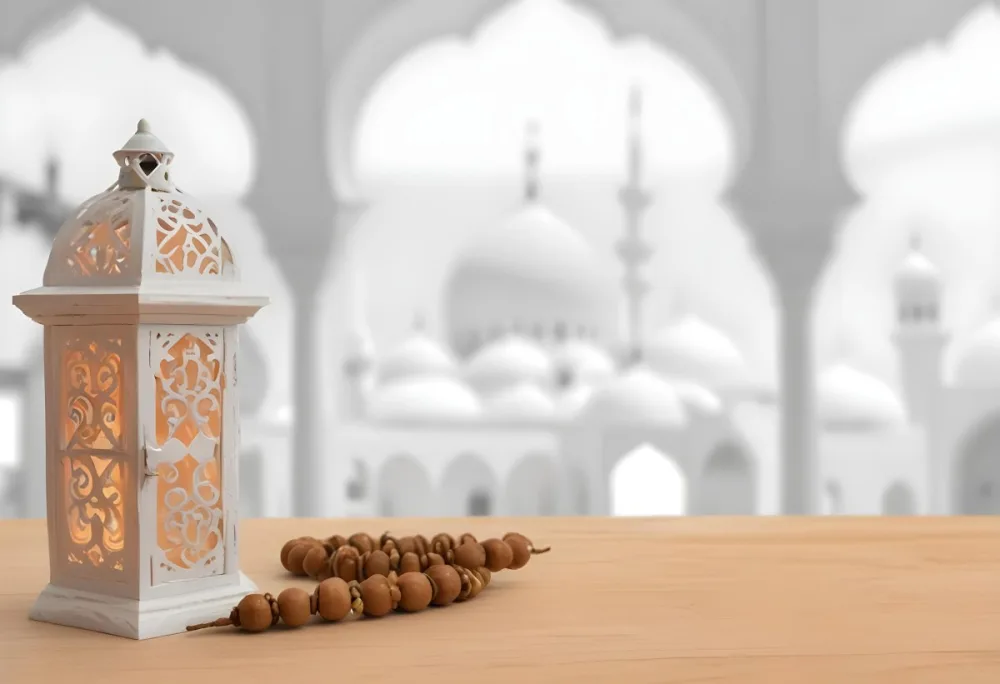 A Lantern And A Tasbih On A Wooden Table In The Background A Mosque With White Arches 10 20ff