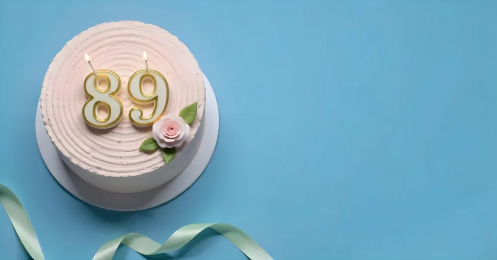 A Pink Cake With Number 89 Candles And A Rose Decoration On Top A Light Green Ribbon On A Blue Background 1 3d4b