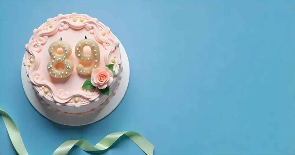 A Pink Cake With Number 89 Candles And A Rose Decoration On Top A Light Green Ribbon On A Blue Background 12 B3f2