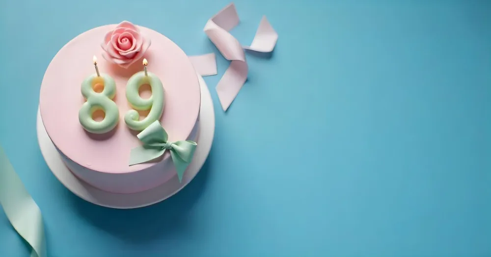 A Pink Cake With Number 89 Candles And A Rose Decoration On Top A Light Green Ribbon On A Blue Background 7 1348