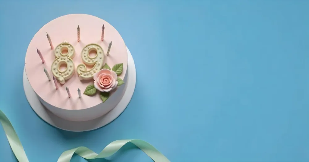 A Pink Cake With Number 89 Candles And A Rose Decoration On Top A Light Green Ribbon On A Blue Background 9 2af6