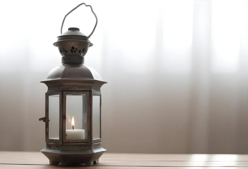 An Antique Metal Lantern With Glass Panels Sits On A Glass Surface A Candle Burning Inside Against A Blurred White Background 18 F29f