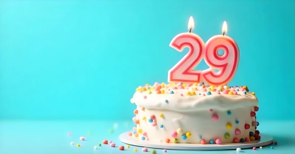 Birthday Cake With White Frosting And Colorful Sprinkles A Candle In The Shape Of The Number 29 Light Blue Background 2 4869