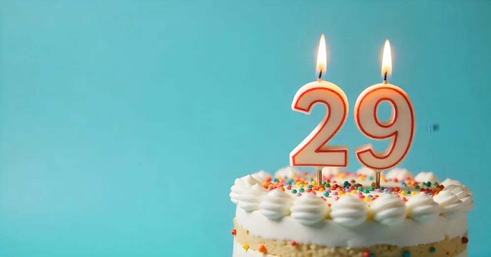 Birthday Cake With White Frosting And Colorful Sprinkles A Candle In The Shape Of The Number 29 Light Blue Background 28 Cb89