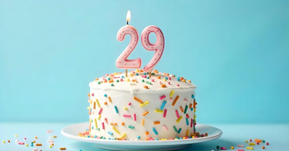 Birthday Cake With White Frosting And Colorful Sprinkles A Candle In The Shape Of The Number 29 Light Blue Background 5 6edd