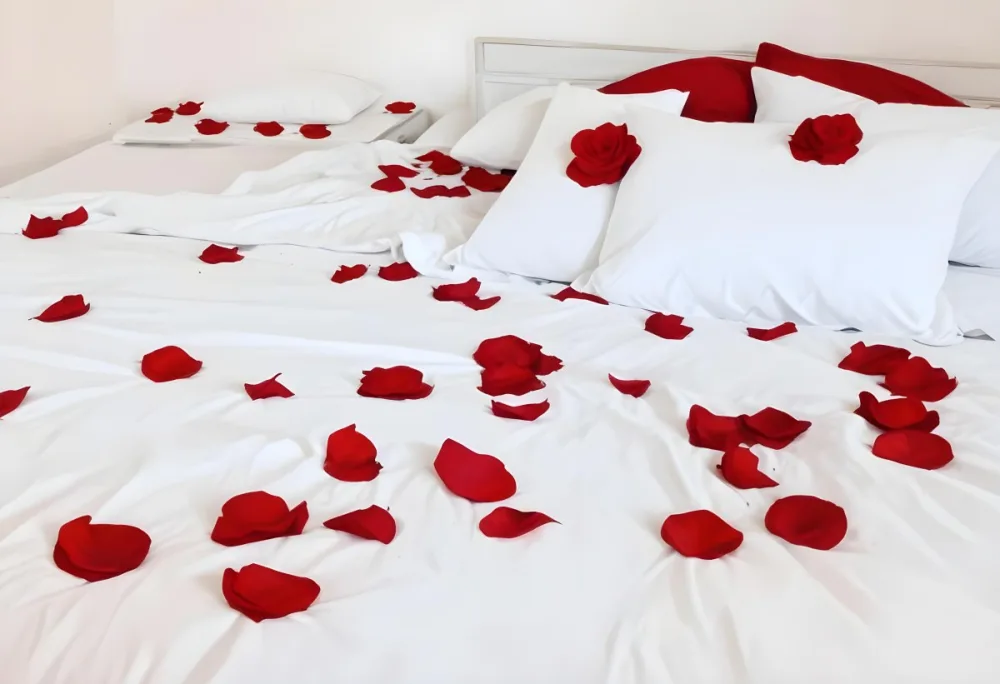 White Bed With Red Pillows And Sheets Covered With Red Rose Petals In A Bedroom 16 13c6