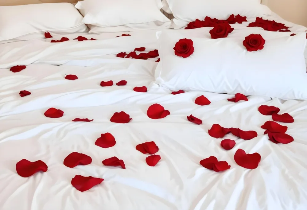 White Bed With Red Pillows And Sheets Covered With Red Rose Petals In A Bedroom 7 B43f