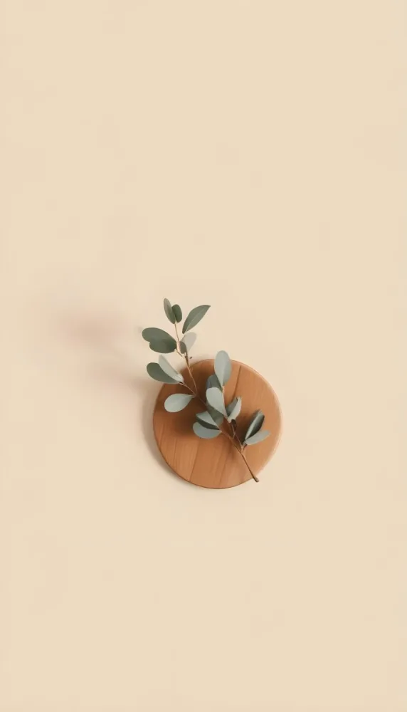A Eucalyptus Branch On A Wooden Coaster Minimalist Style Light Beige Background Natural Lighting Clean And Simple Composition Natural Elements Neutral Color Palette 3 Dbda