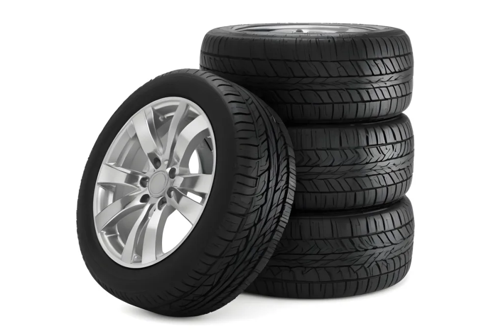 A Stack Of Four Black Tires With Black Rims One Tire Is Leaning Against The Stack The Background Is Black 32 D6f4