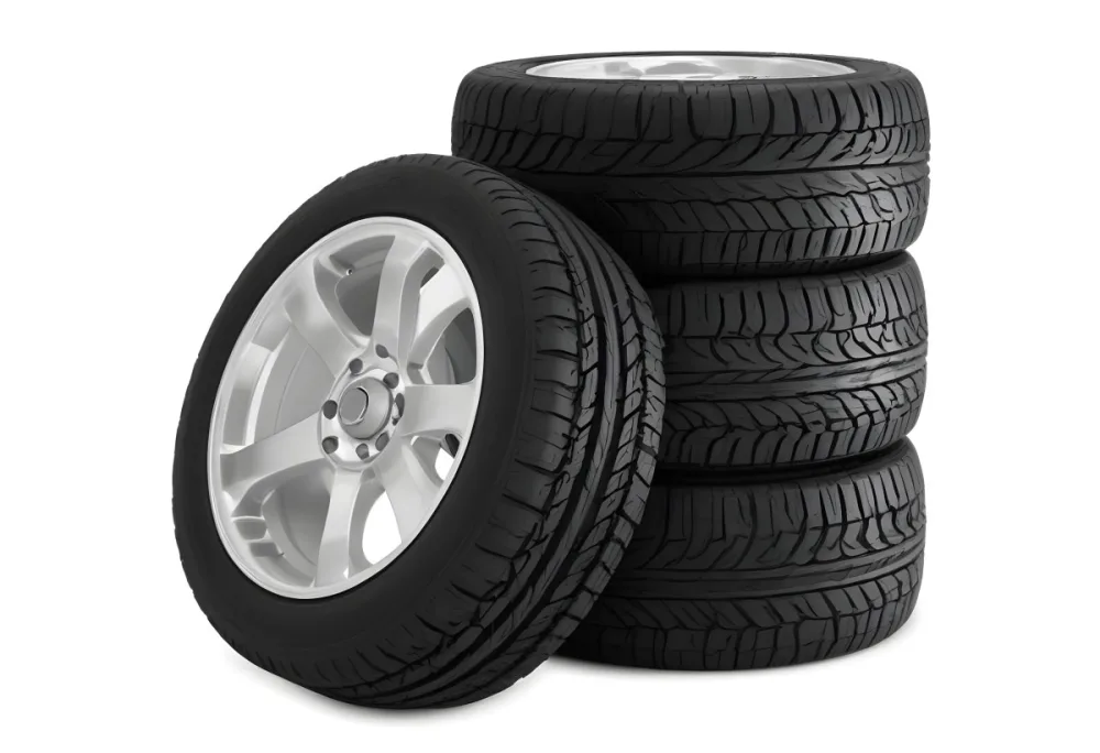 A Stack Of Four Black Tires With Black Rims One Tire Is Leaning Against The Stack The Background Is Black 7 198a
