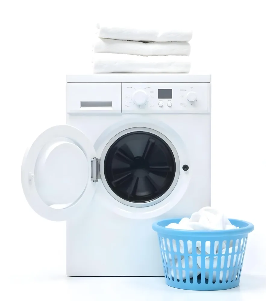 A White Washing Machine With Three White Pillows And Three Towels On Top A Blue Basket With White Clothes On A White Background 36 34f0
