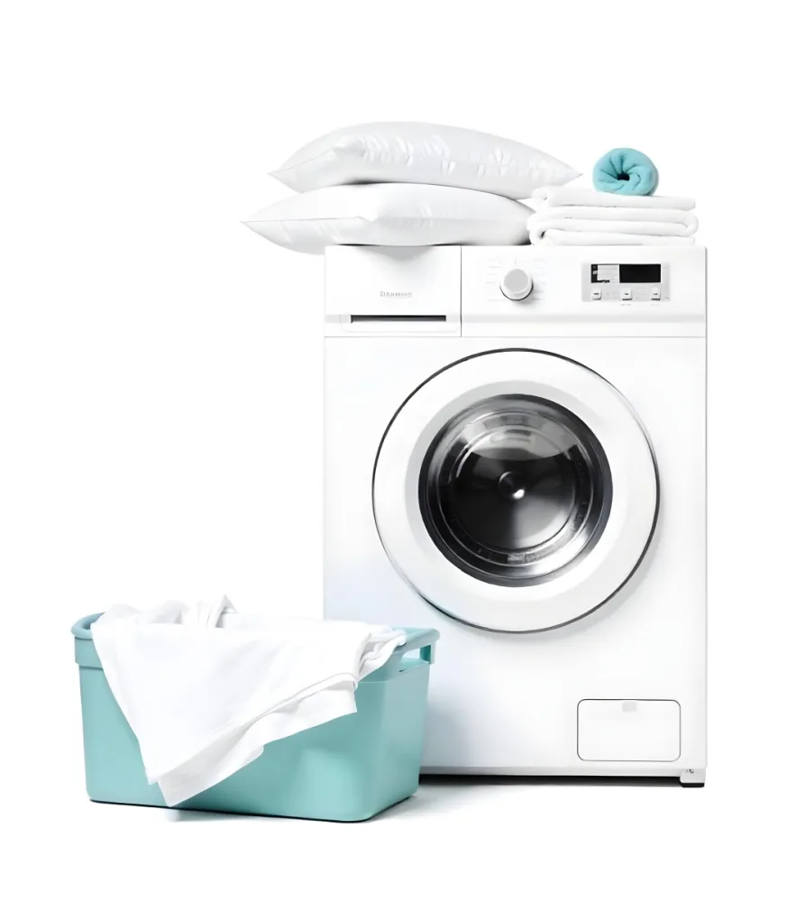 A White Washing Machine With Three White Pillows And Three Towels On Top A Blue Basket With White Clothes On A White Background 6 963c