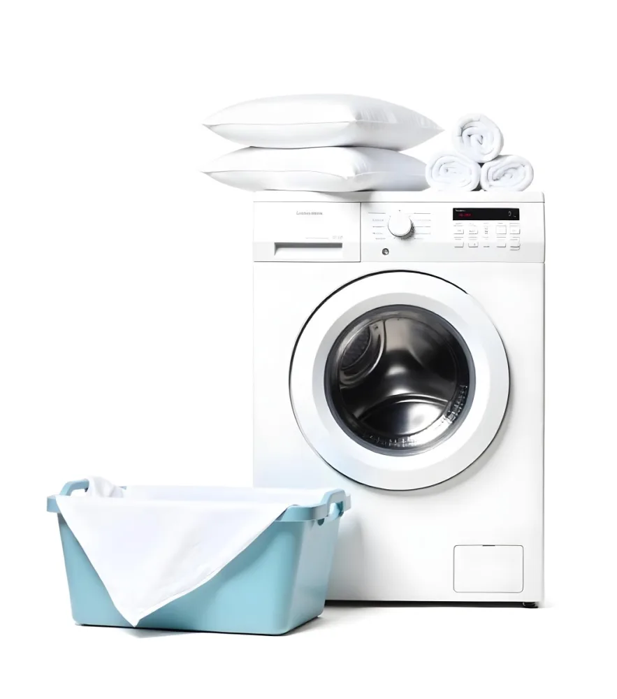 A White Washing Machine With Three White Pillows And Three Towels On Top A Blue Basket With White Clothes On A White Background 60 65a5