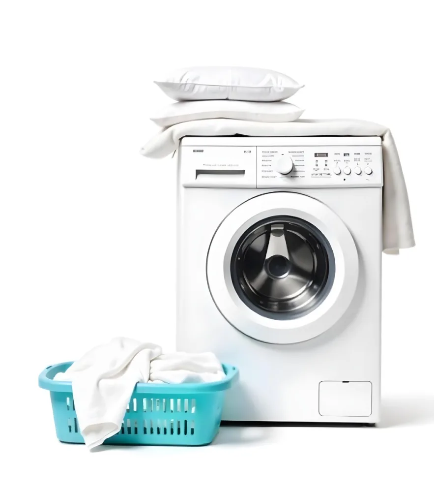 A White Washing Machine With Three White Pillows And Three Towels On Top A Blue Basket With White Clothes On A White Background 64 B28e
