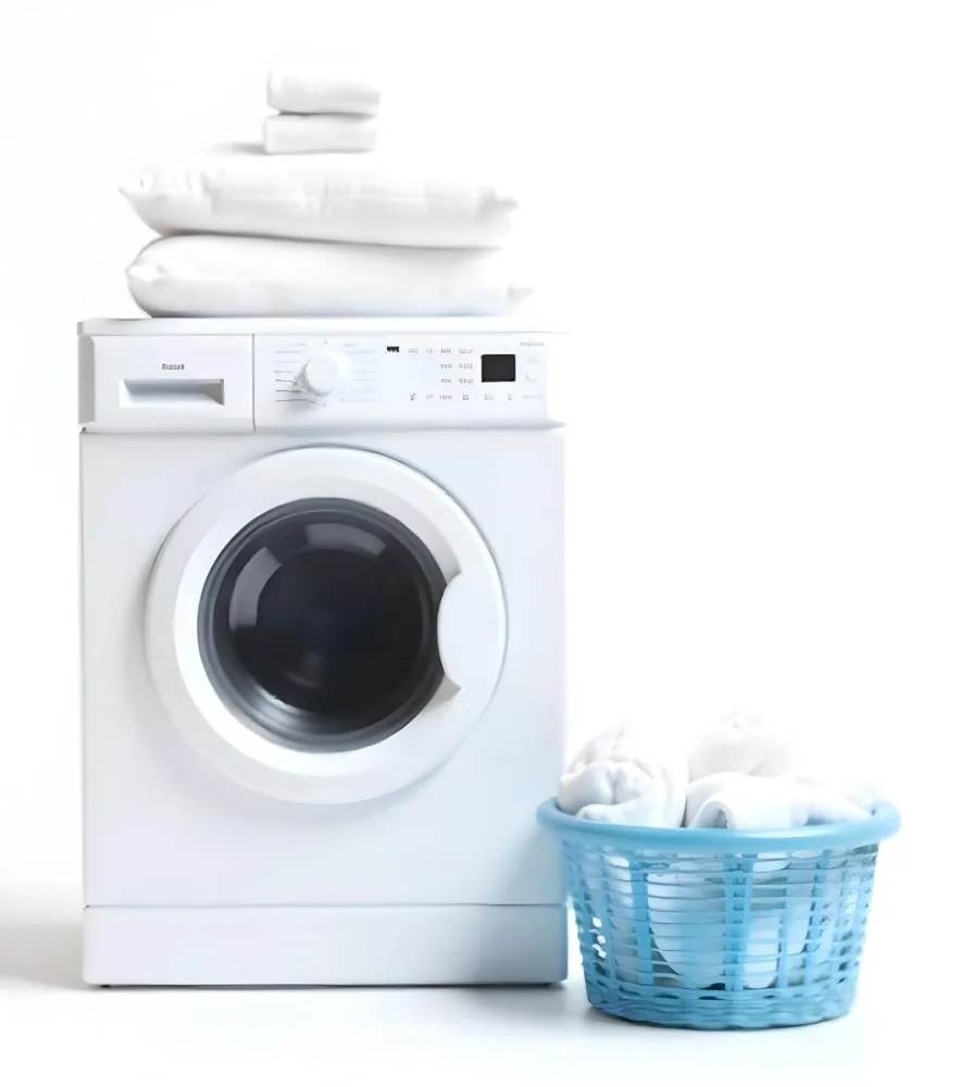 A White Washing Machine With Three White Pillows And Three Towels On Top A Blue Basket With White Clothes On A White Background 7 C37c