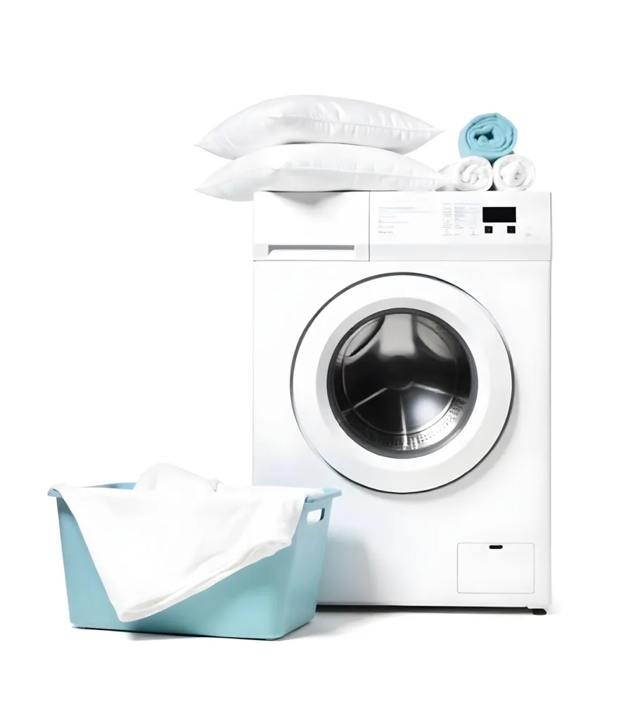 A White Washing Machine With Three White Pillows And Three Towels On Top A Blue Basket With White Clothes On A White Background 8 Acae