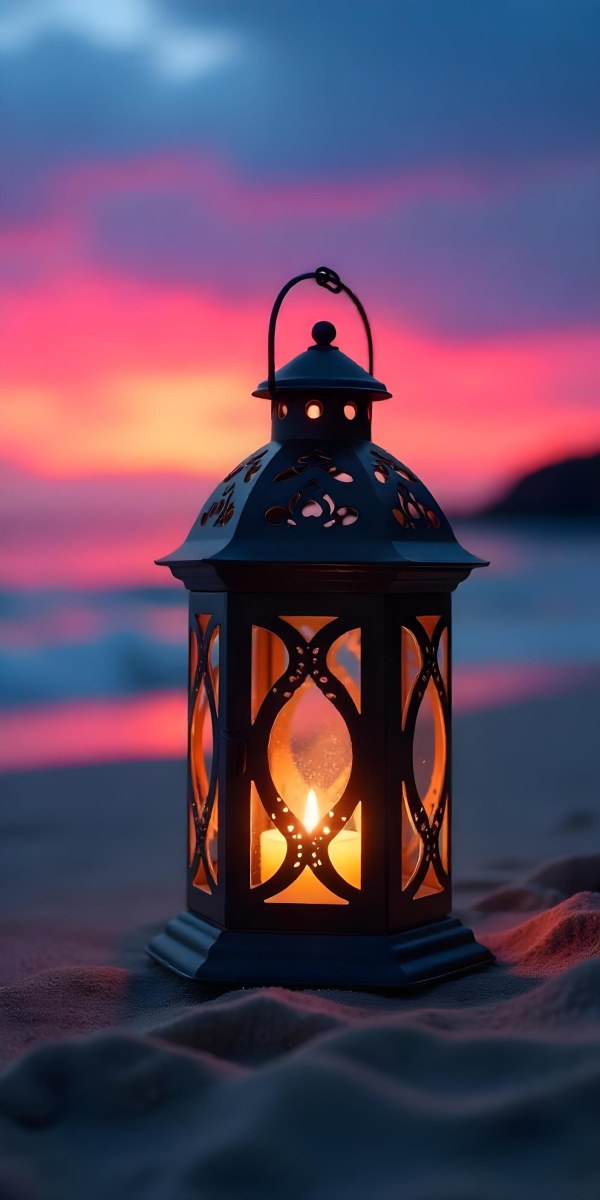 A Black Metal Lantern With Intricate Cutouts Glowing With Warm Light Sits On A Sandy Beach With A Vibrant Pink And Blue Sunset Sky 6 F063