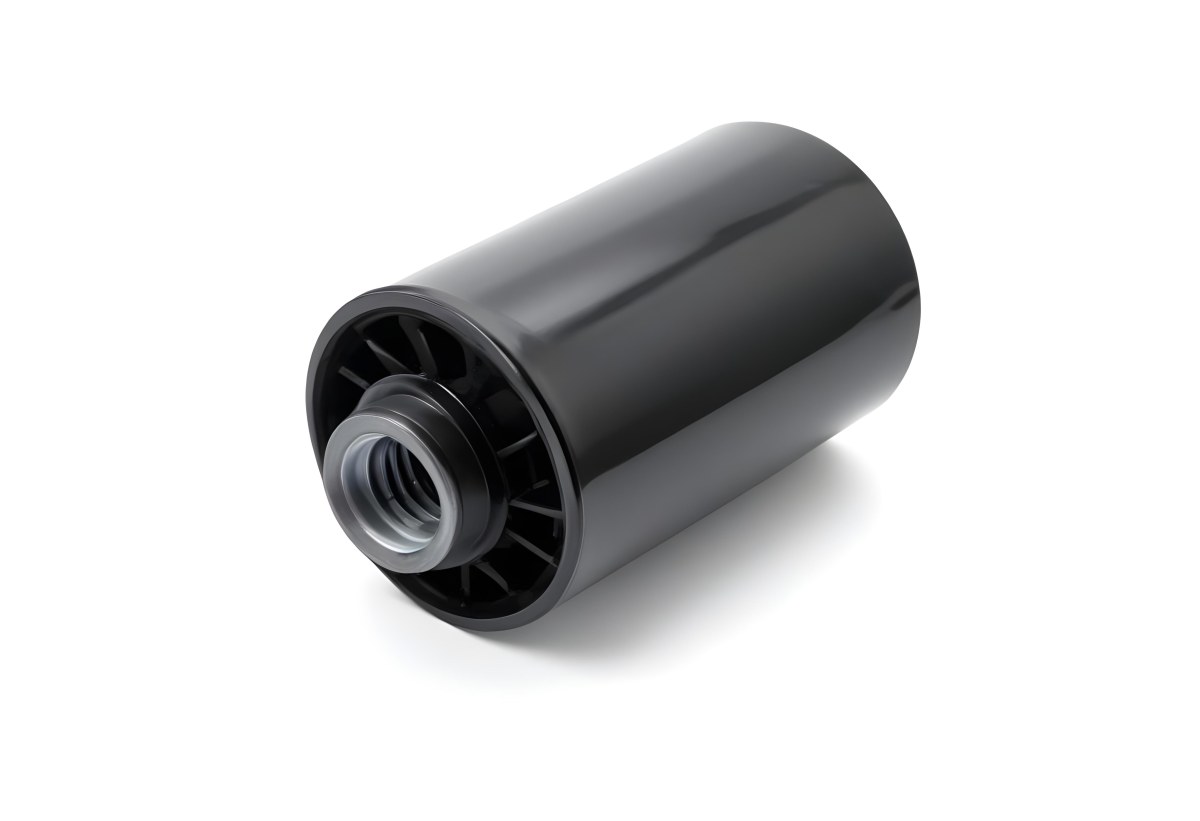 A Black Oil Filter With A Black Threaded Insert Lying On A Black Surface With A Slight Shadow Showcasing Its Cylindrical Shape And Construction 7 538c