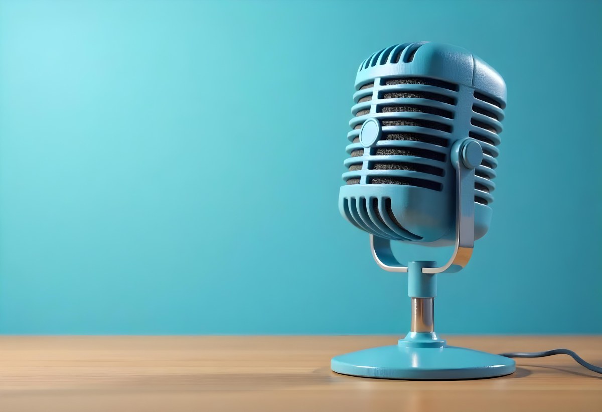 A Blue Vintage Microphone On A Wooden Table The Background Is A Solid Light Blue Color The Microphone Is Slightly Angled To The Left 12 E855