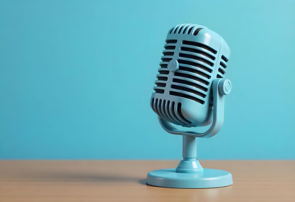 A Blue Vintage Microphone On A Wooden Table The Background Is A Solid Light Blue Color The Microphone Is Slightly Angled To The Left 13 647a