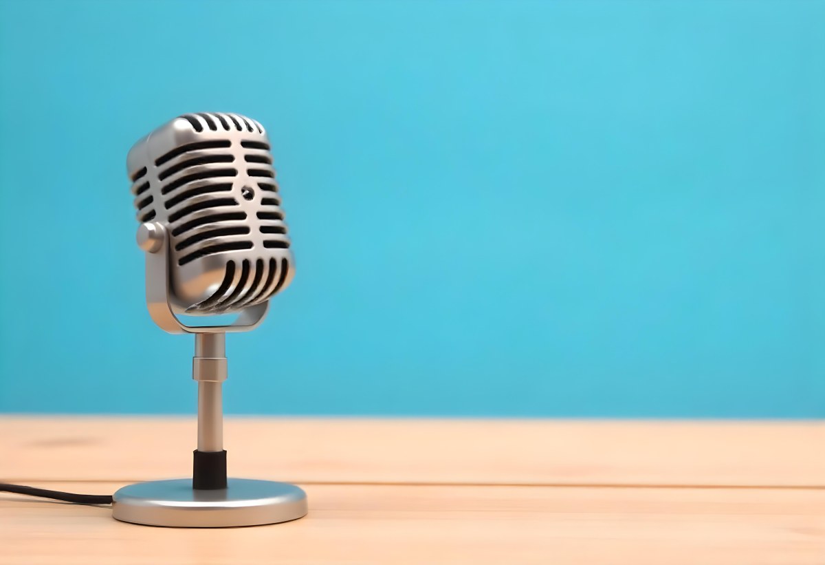 A Blue Vintage Microphone On A Wooden Table The Background Is A Solid Light Blue Color The Microphone Is Slightly Angled To The Left 16 8d01