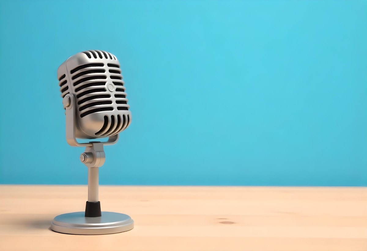 A Blue Vintage Microphone On A Wooden Table The Background Is A Solid Light Blue Color The Microphone Is Slightly Angled To The Left 2 D237