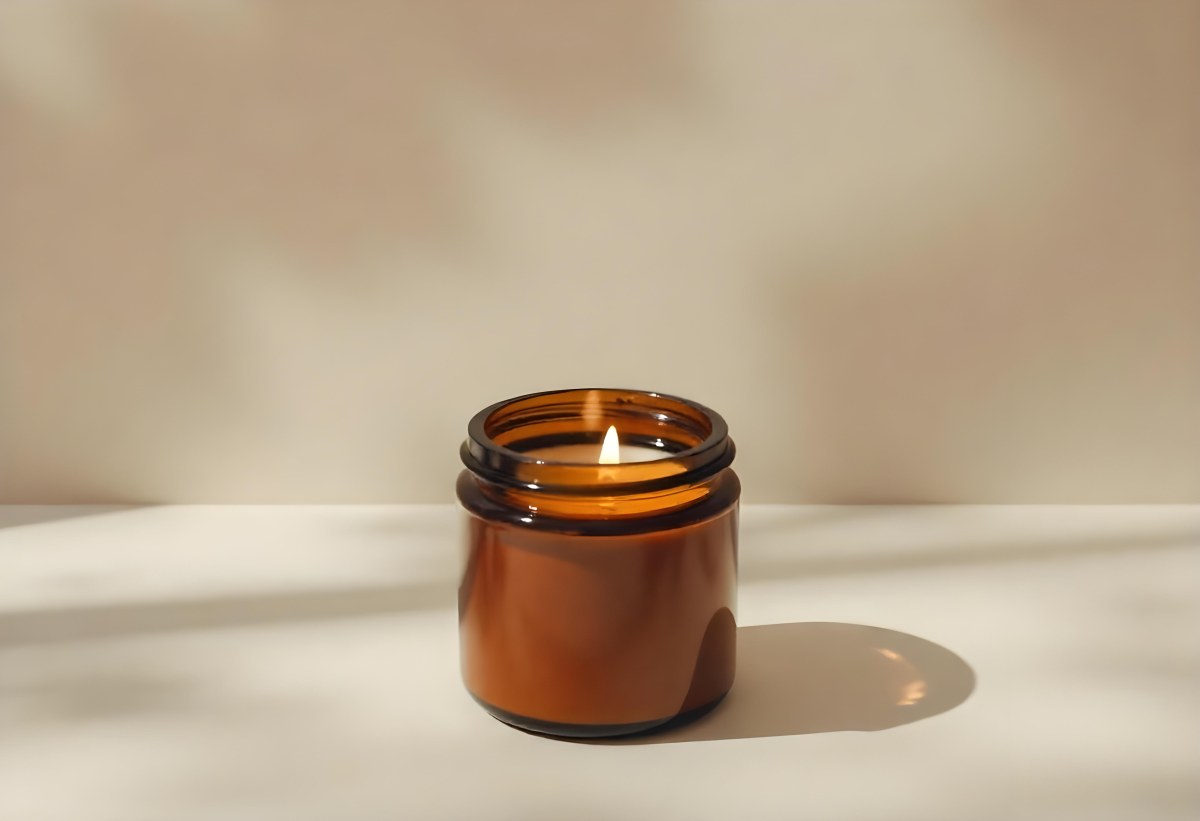 A Brown Glass Jar Candle With A Flickering Flame Casting Soft Shadows On A Neutral Surface Minimalist Aesthetic Warm Lighting Simple Composition Cozy Atmosphere 12 6415