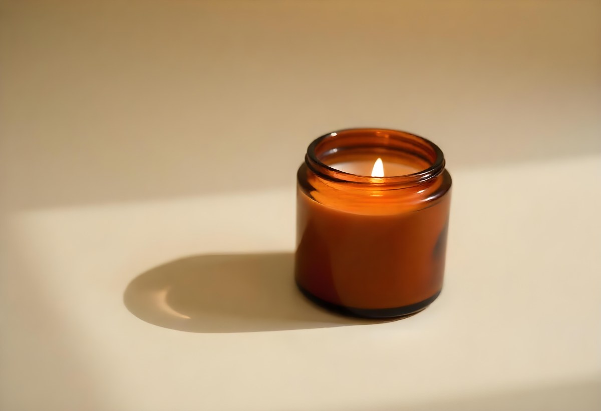 A Brown Glass Jar Candle With A Flickering Flame Casting Soft Shadows On A Neutral Surface Minimalist Aesthetic Warm Lighting Simple Composition Cozy Atmosphere 13 6298