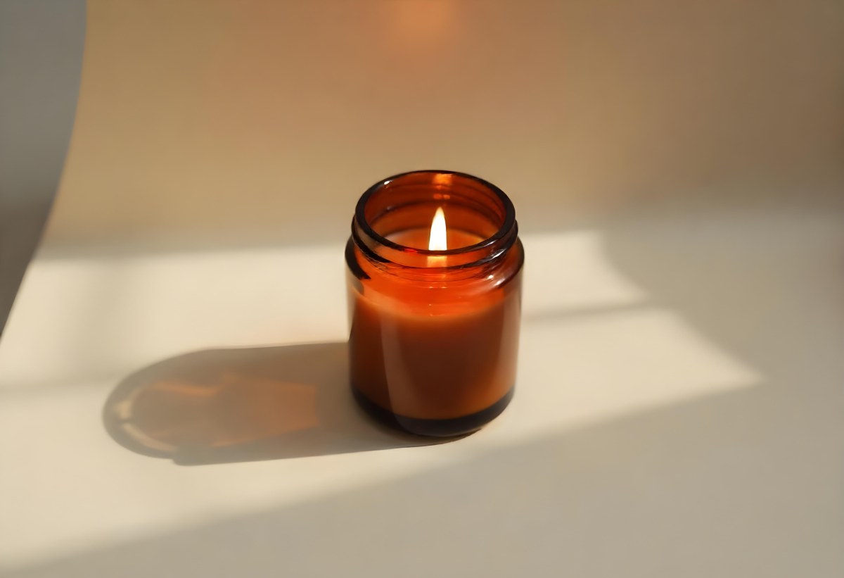 A Brown Glass Jar Candle With A Flickering Flame Casting Soft Shadows On A Neutral Surface Minimalist Aesthetic Warm Lighting Simple Composition Cozy Atmosphere 26 6fe2